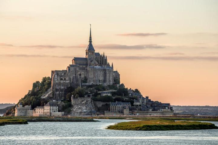 a large body of water with Mont Saint-Michel in the background