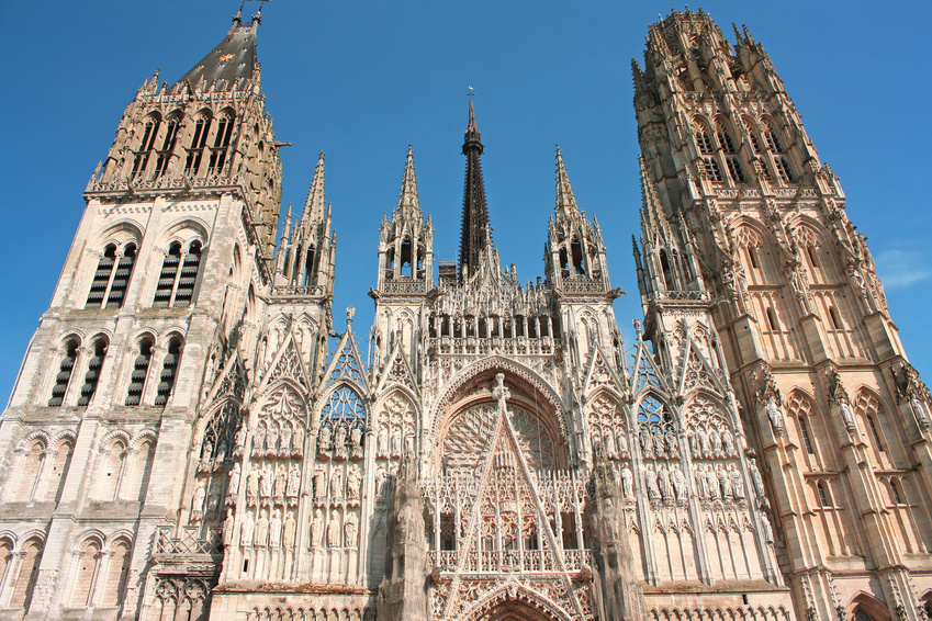 France. Rouen.Cathédrale Notre-Dame de Rouen a large clock tower in front of a tall building with Rouen Cathedral in the background