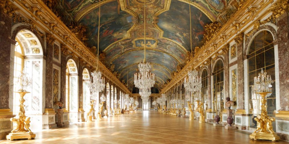 Versailles-Second-1024×512 a large building with a clock on a table